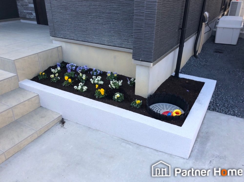 名古屋市守山区にて新築外構エクステリア工事を行いました。玄関まわりを彩る花壇を作成いたしました。水栓も近くにございますので植物や花を育てたりできますね。ブロックとジョリパットで枠を作っています。　パートナーホーム：名古屋市名東区