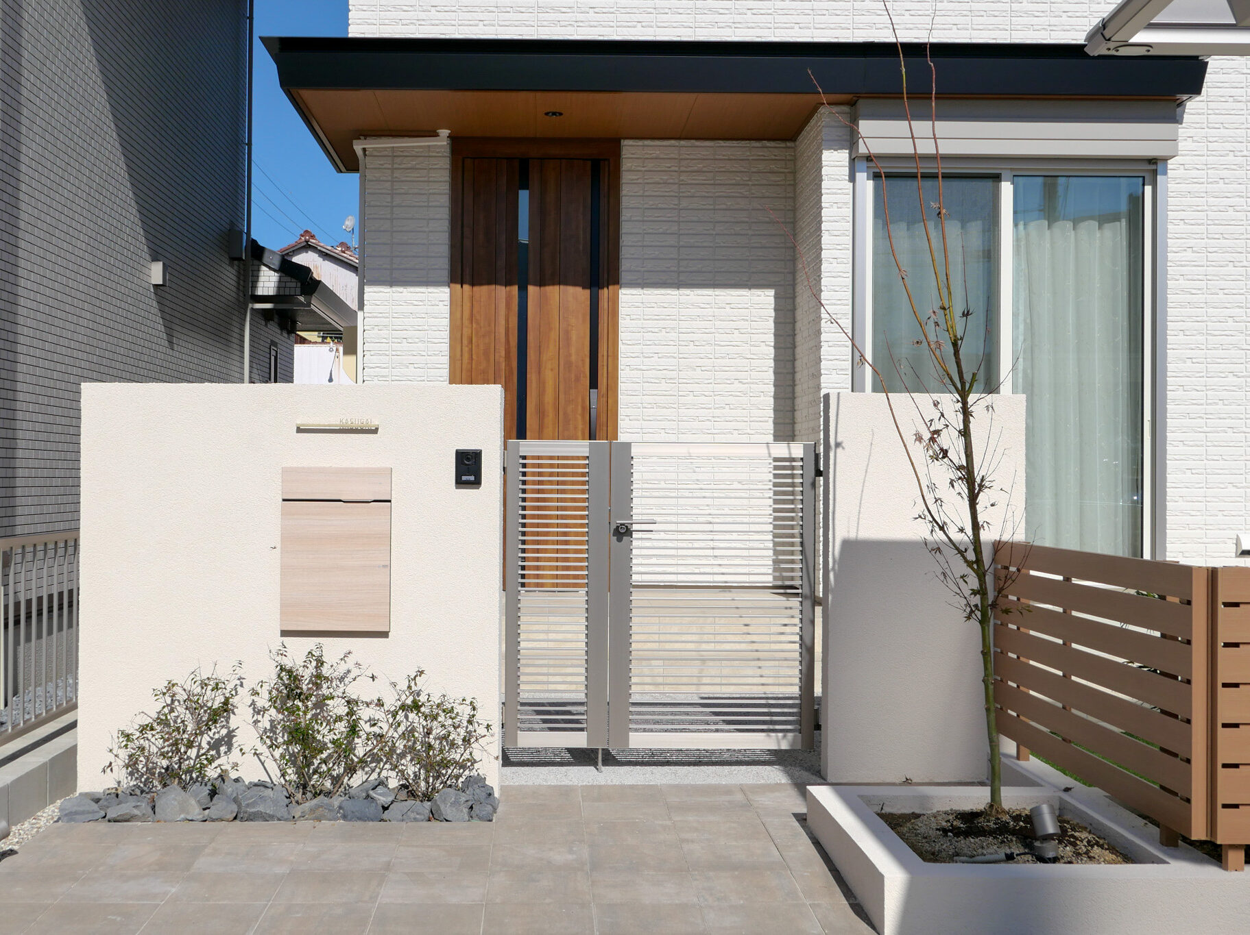 外構は色で変わる！カラー別に見るデザインアイデア集　アイボリーの門塀+アプローチ+木目調フェンス|パートナーホーム