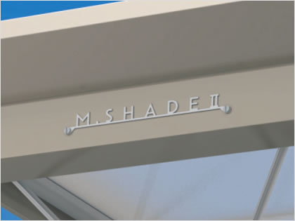 エンブレム M.シェードⅡのロゴタイプを象ったステンレス製のエンブレムを取り付けてあります。　三協アルミ　車庫まわり　カーポート　モダン　おしゃれ　エクステリア　愛知・名古屋の外構専門店パートナーホームのエクステリア　製品一覧　カーポート　M.シェードⅡ上吊りタイプ|パートナーホーム
